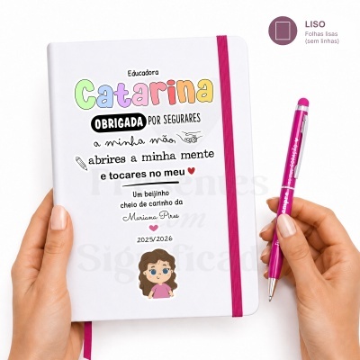 Caderno branco com elástico rosa e caneta rosa com texto branco num fundo branco.