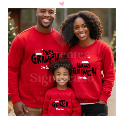 Três pessoas vestem camisolas vermelhas com texto preto e branco 'GRINCH' e nomes próprios, usando chapéus de Natal nas estampas.
