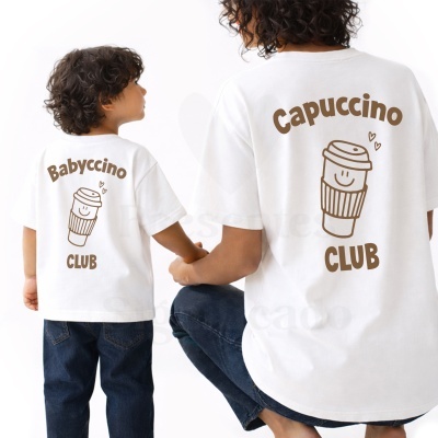 Duas pessoas de costas usando t-shirts brancas com copos de café e inscrições Babyccino CLUB e Capuccino CLUB