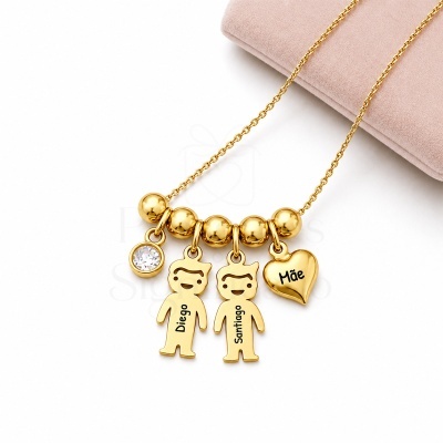 Colar dourado com pingentes de crianças e coração com nomes, pedra brilhante e caixa rosa.