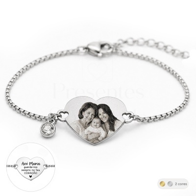 Pulseira metálica prateada com pendente em coração com foto gravada de três pessoas.