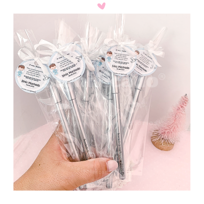 Conjunto de canetas embaladas com etiquetas redondas e laços brancos