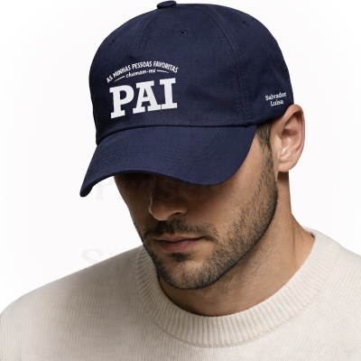 Boné azul-escuro com texto branco PAI e nomes Salvador Luísa, usado por homem com camisola branca.