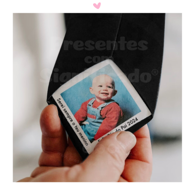 Etiqueta quadrada com foto de bebé e texto Dia do Pai 2024 numa peça de tecido preto