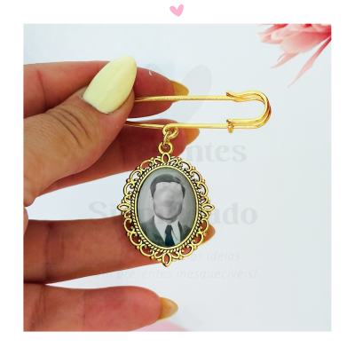 Alfinete de segurança dourado com fotografia em preto e branco e moldura detalhada