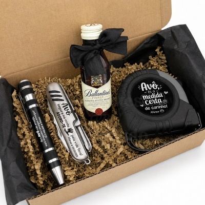 Caixa de presente com caneta, canivete, garrafa de whisky e fita métrica em papelaria personalizada
