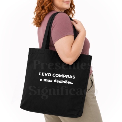 Mala tote preta com texto em branco LEVO COMPRAS e más decisões