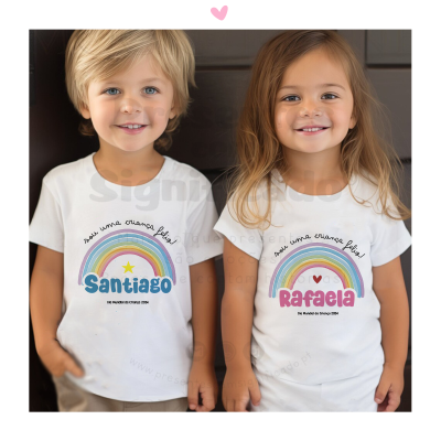 Duas crianças com t-shirts brancas com arco-íris e nomes Santiago e Rafaela.