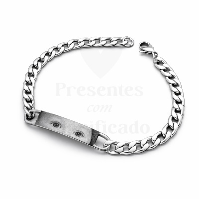 Pulseira metálica prateada com placa gravada com imagem de olhos humanos.