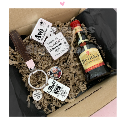 Chaveiro com vários pendentes e garrafa pequena de Licor Beirão numa caixa de cartão com enchimento de papel