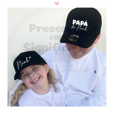 Homem e criança a usar bonés pretos com inscrições em branco num fundo branco