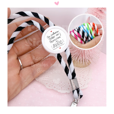 Pulseira trançada preto e branco com etiqueta estampada em fundo rosa