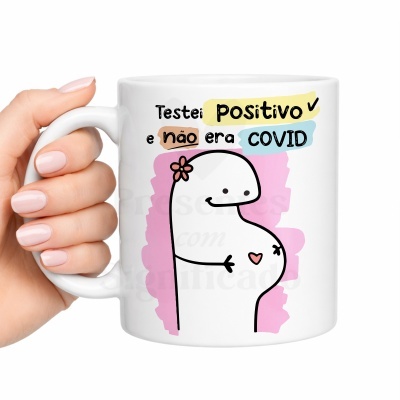 Caneca branca com ilustração de boneco grávido e texto colorido sobre teste positivo