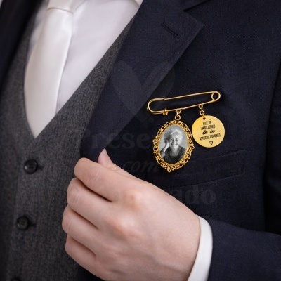 Pino dourado com foto e medalha com texto preso a casaco azul escuro