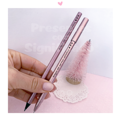 Dois lápis de sobrancelha rosa metálico com texto e uma mão segurando, com fundo rosa e árvore decorativa