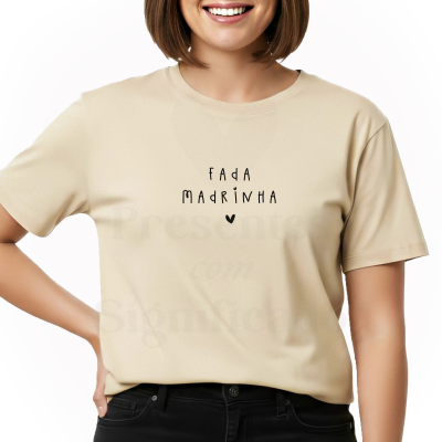 T-shirt bege com texto preto FADA MADRINHA e coração, usada por pessoa de cabelo castanho.