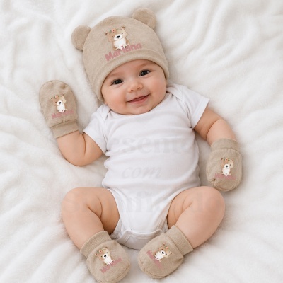 Bebé sorridente com touca e meias bege com orelhas de ursinho e nome Mariana