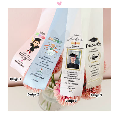 Faixas de formatura em tecido com textos e ilustrações, sobre flores em vaso de vidro.