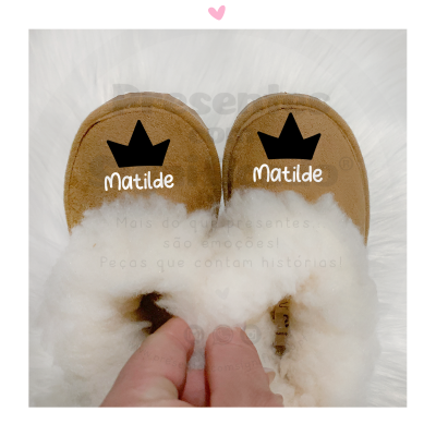 Chinelos castanhos com interior branco felpudo e nomes 'Matilde' com coroa preta