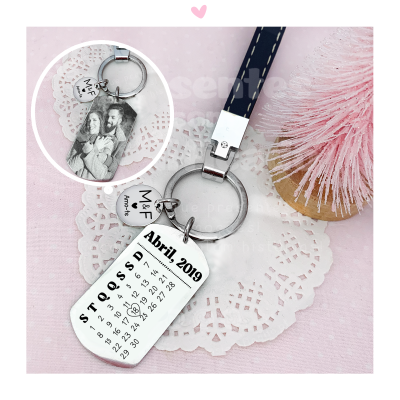 Porta-chaves com calendário de Abril 2019 e medalhas de metal, em superfície rosa com objeto decorativo