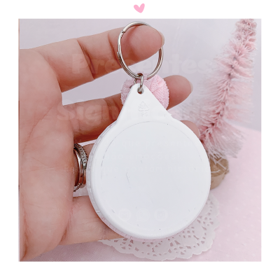 Porta-chaves branco redondo com argola e fundo com decoração natalícia rosa