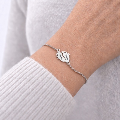 Pulseira prateada com pendentes em forma de pezinhos com nomes Martim e Duarte