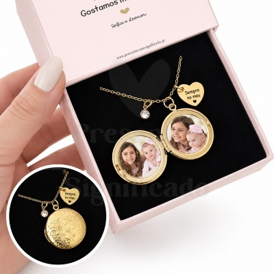 Colar dourado com medalhão e pingentes numa caixa rosa.