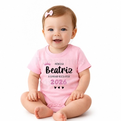 Bebé com body rosa claro e presilha rosa no cabelo sentada