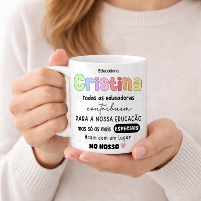 Caneca branca com texto colorido e várias fontes com mensagem para educadora Cristina, segurada por pessoa com camisola creme