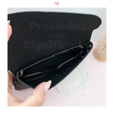 Estojo preto para óculos com óculos dentro e fundo branco com decoração