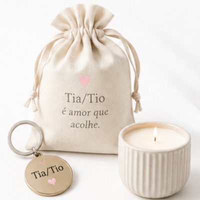Saco de tecido cru, porta-chaves metálico e vela acesa em cerâmica creme com frase para tia/tio.