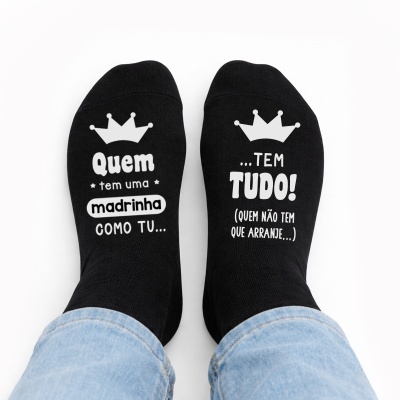 Meias pretas com texto branco e coroa, usadas com calças de ganga