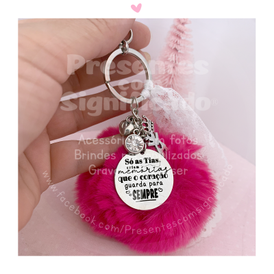 Porta-chaves com pompom rosa e medalhão prateado com texto em português