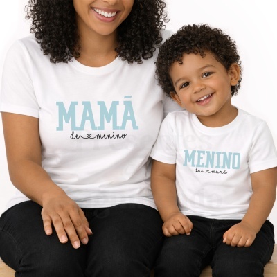 T-shirts brancas com text MAMÃ de menino e MENINO da mamã usadas por mulher e criança sentados