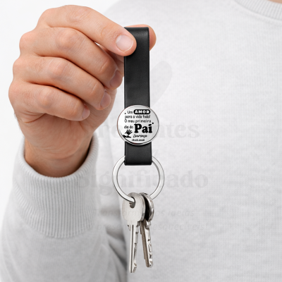 Chaveiro preto com texto personalizado em branco e preto e três chaves penduradas