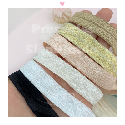 Faixas elásticas coloridas com textura cintilante sobre mão