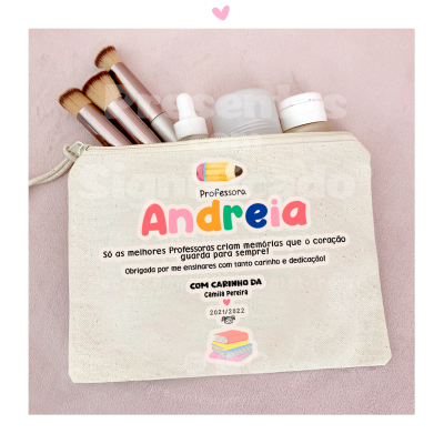 Bolsa bege com pincéis de maquilhagem e produtos cosméticos com texto dedicado à professora Andreia