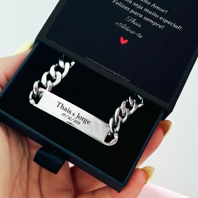Pulseira prateada com plaqueta gravada dentro de caixa preta