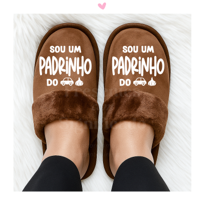 Chinelos castanhos felpudos com texto em branco dizendo 'SOU UM PADRINHO DO' e desenhos de carro e alho