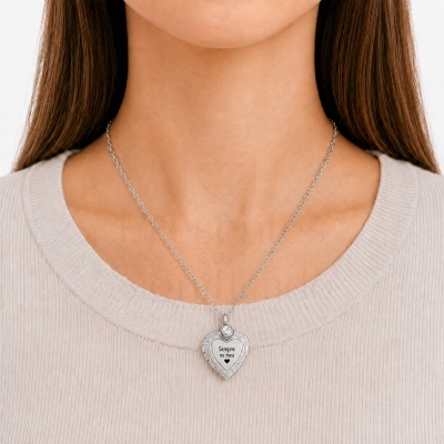 Colar com pendente em forma de coração, prata, usado no pescoço de mulher.