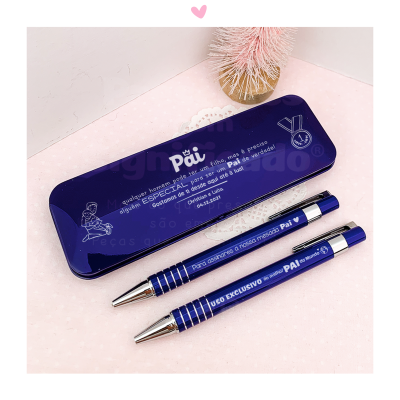 Estojo metálico azul com texto e duas canetas azuis metálicas com apontadores prateados em fundo rosa claro com bolinhas
