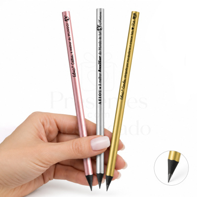 Três lápis metálicos personalizados em rosa, prata e dourado, segurados por mão com unhas manicadas