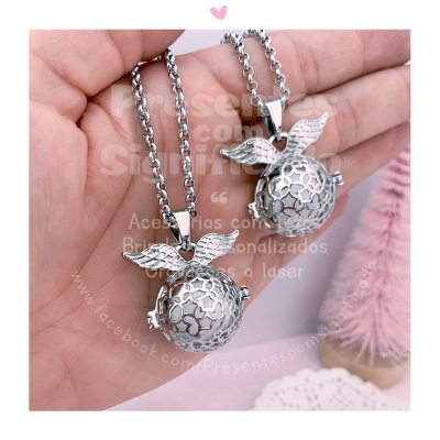 Colares prateados com pendentes esféricos e asas em fundo rosa