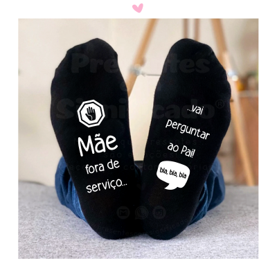 Par de meias pretas com textos e símbolo de mão em branco usadas por criança de calças jeans azuis