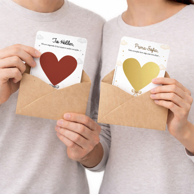 Cartões com corações dentro de envelopes castanhos nas mãos de duas pessoas
