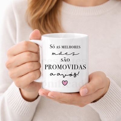 Caneca branca com frase Só as melhores mães são promovidas a avós! segurada por mulher com suéter claro.