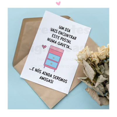 Postal com móvel de gavetas rosa e azul e texto em português, envelope castanho e flores secas