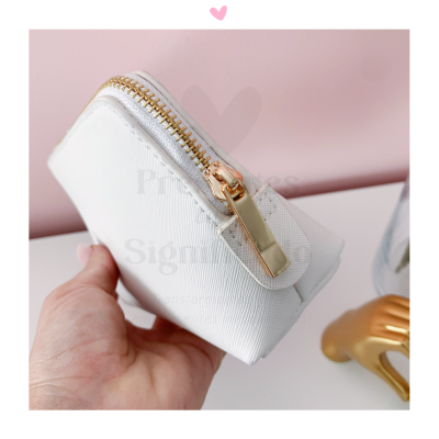 Bolsa pequena branca com fecho dourado e mão segurando