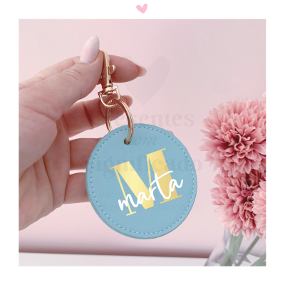 Porta-chaves redondo azul claro personalizado com letra M amarela e nome Marta branco com fecho dourado