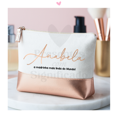 Necessaire branca e rosa com texto personalizado sobre mesa branca.